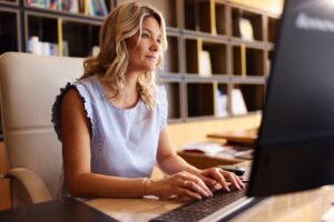 Mid adult female paralegal working on desktop PC in the office.